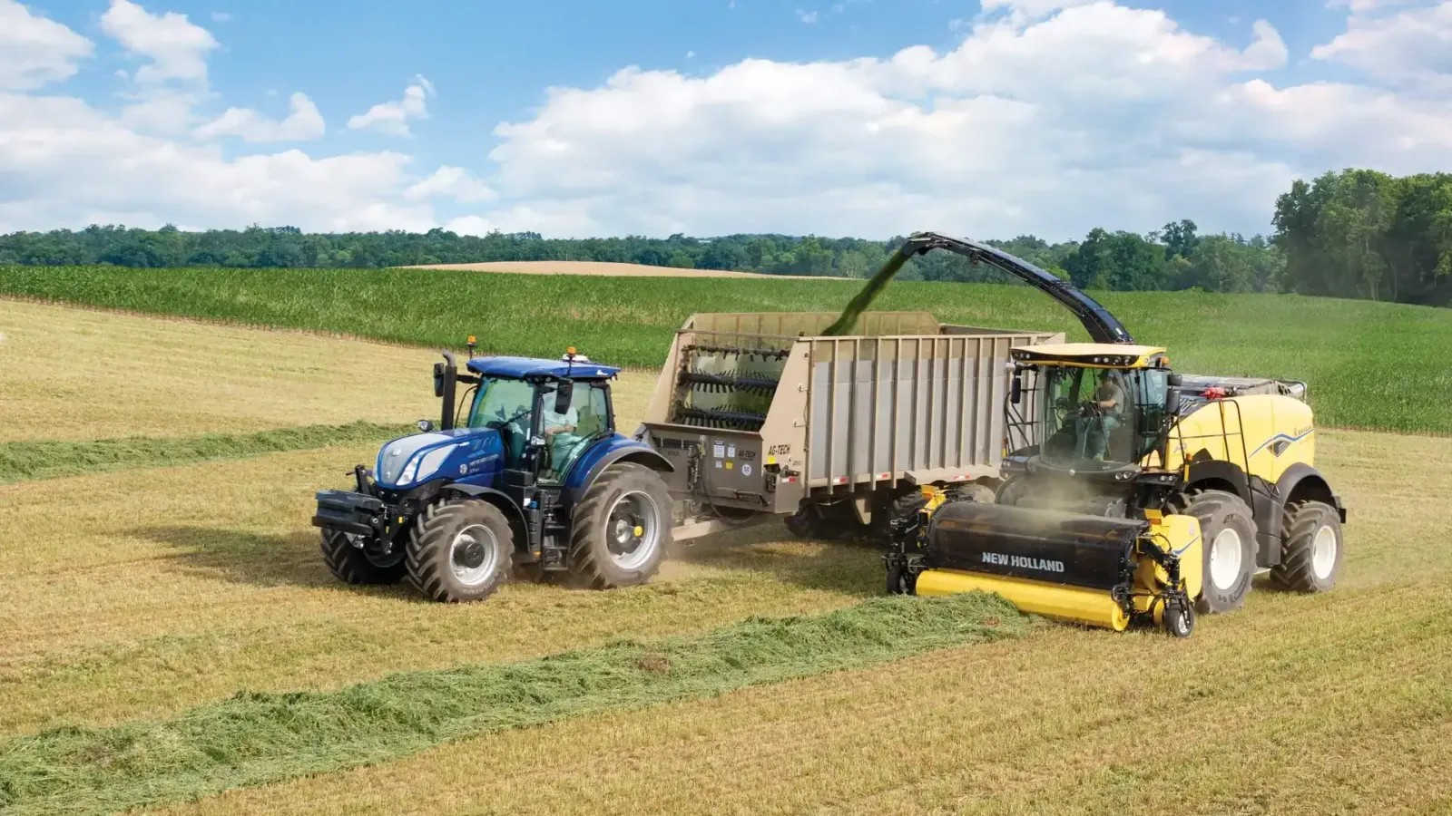 New Holland FR forage harvester collecting windrowed forage and filling a trailer beside a tractor